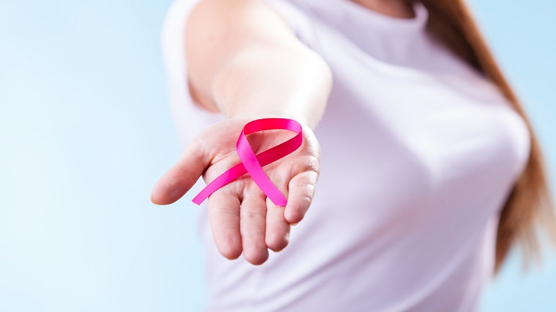 Woman with breast cancer awareness ribbon on hand